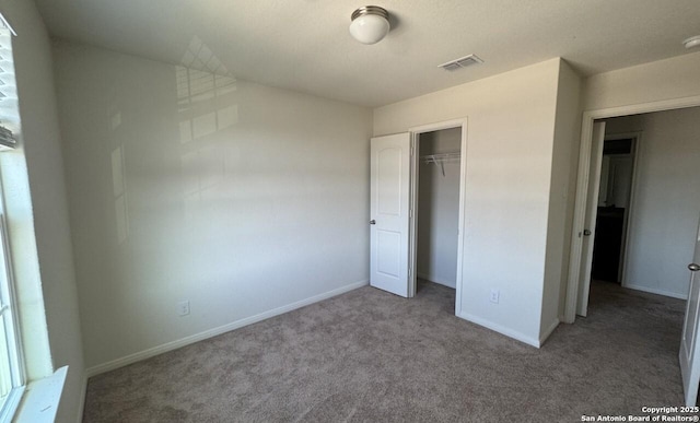 unfurnished bedroom featuring light colored carpet and a closet