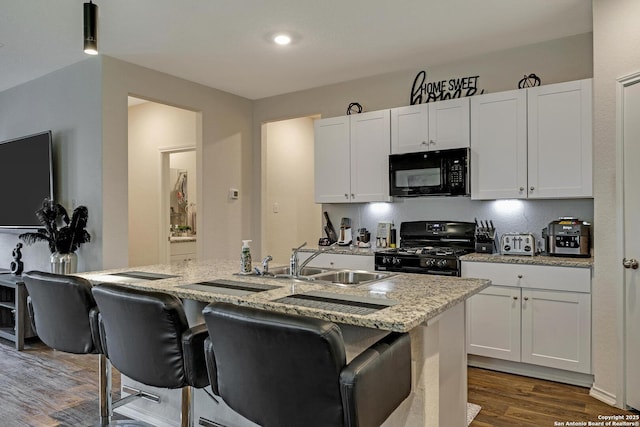 kitchen with white cabinetry, sink, a kitchen island with sink, and black appliances