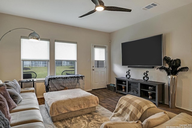 living room featuring dark wood-type flooring and ceiling fan