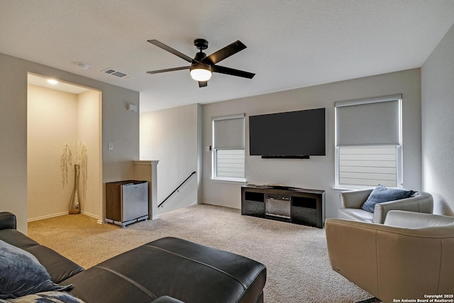 living room featuring light colored carpet and ceiling fan