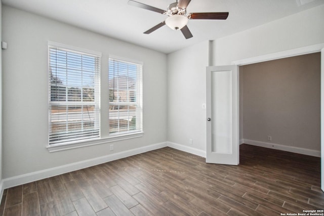 spare room featuring dark wood-type flooring, ceiling fan, and french doors