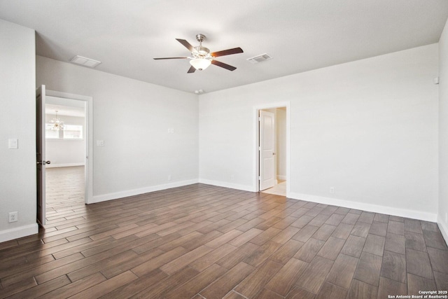 spare room featuring dark hardwood / wood-style flooring and ceiling fan with notable chandelier