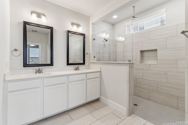 bathroom with vanity and tiled shower