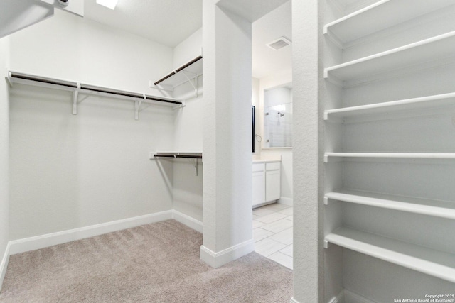 walk in closet featuring light colored carpet