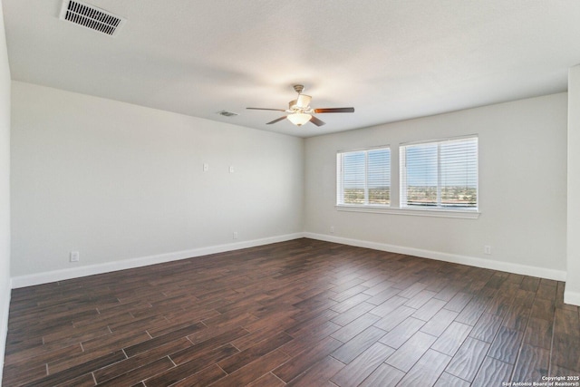 spare room featuring dark wood-type flooring and ceiling fan