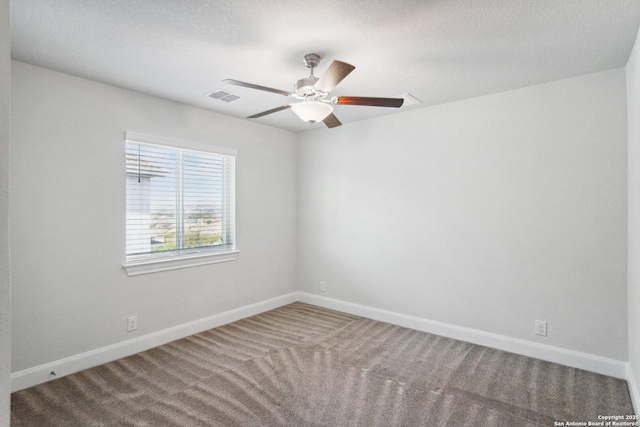 carpeted empty room with ceiling fan and a textured ceiling