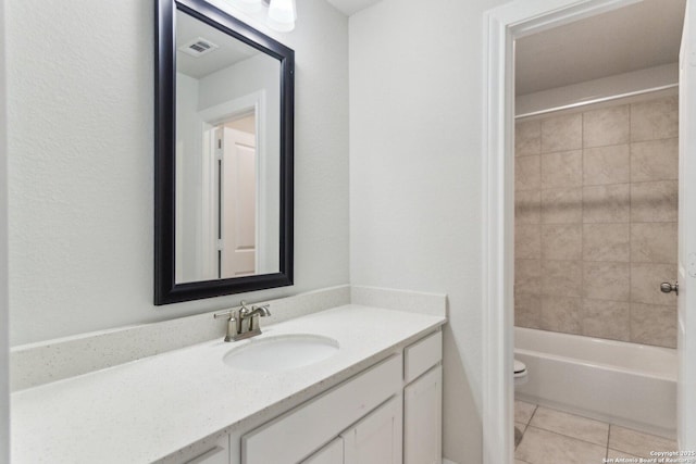 full bathroom featuring tiled shower / bath combo, vanity, tile patterned floors, and toilet