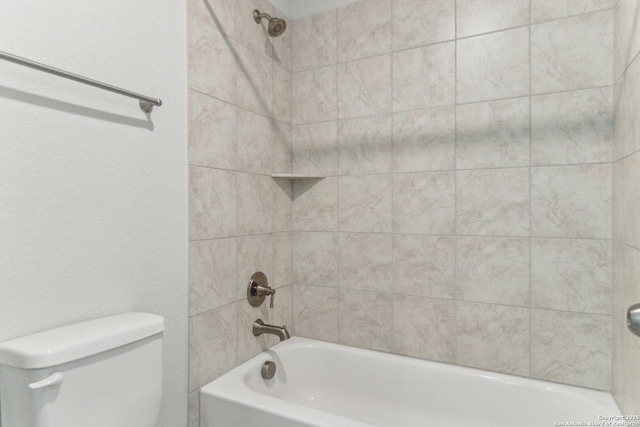 bathroom featuring tiled shower / bath combo and toilet