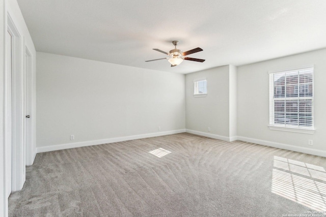 carpeted spare room featuring ceiling fan