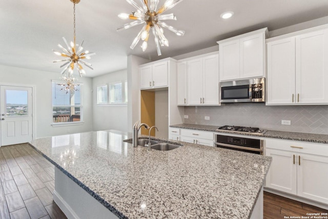 kitchen featuring white cabinetry, appliances with stainless steel finishes, sink, and a center island with sink