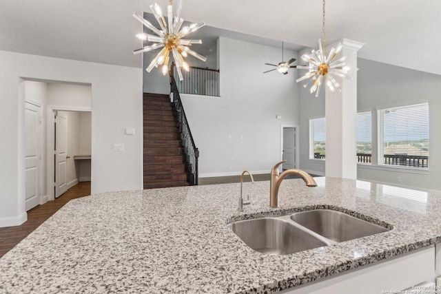 kitchen featuring light stone countertops, sink, and a notable chandelier