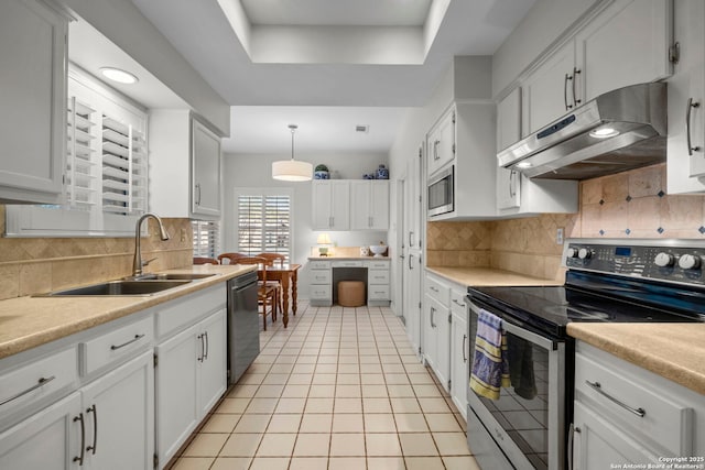 kitchen with stainless steel appliances, white cabinetry, and decorative light fixtures