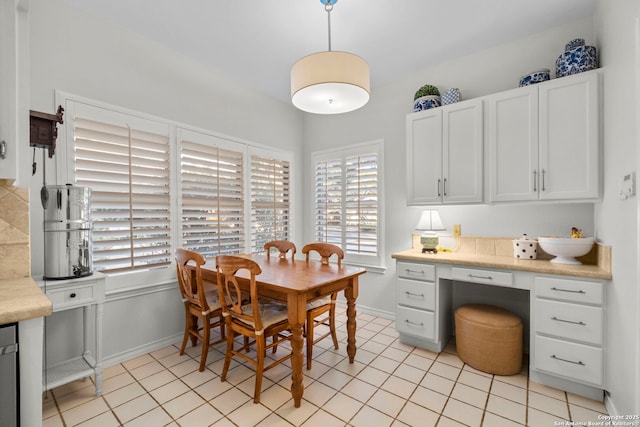 dining area featuring light tile patterned floors and built in desk