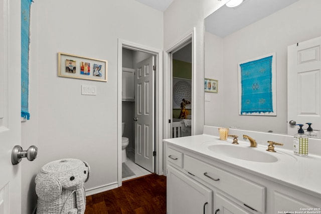 bathroom with vanity, wood-type flooring, and toilet