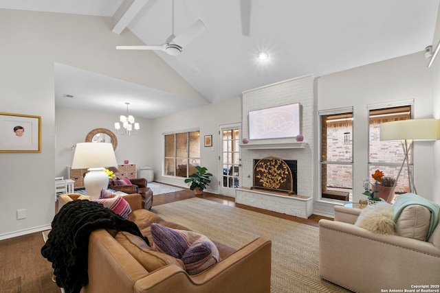 living room featuring hardwood / wood-style flooring, beam ceiling, high vaulted ceiling, a fireplace, and ceiling fan with notable chandelier