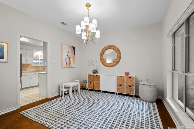 interior space featuring vanity, decorative backsplash, wood-type flooring, and a chandelier