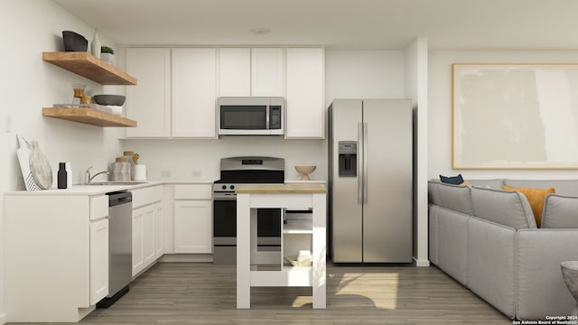 kitchen with stainless steel appliances, white cabinetry, sink, and hardwood / wood-style floors