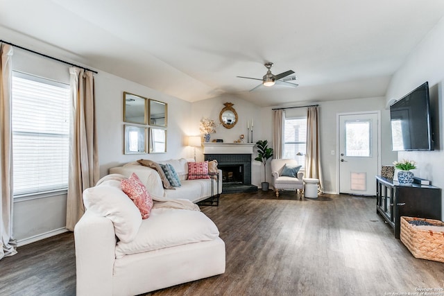 living room with a fireplace, dark wood-type flooring, and ceiling fan