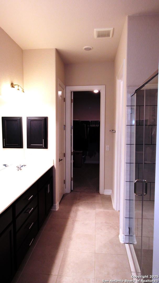 bathroom with tile patterned flooring, vanity, and an enclosed shower