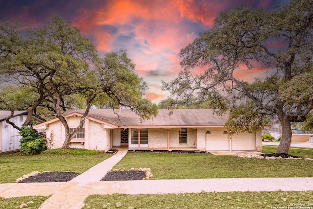 view of front of home with a garage and a yard