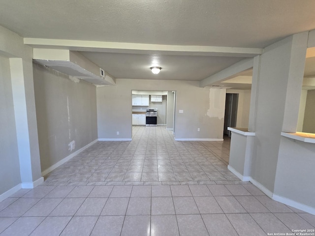 tiled empty room featuring a textured ceiling