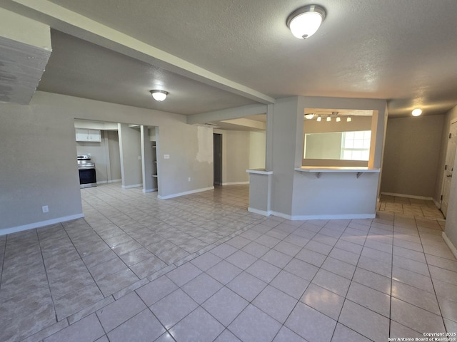 tiled empty room featuring a textured ceiling