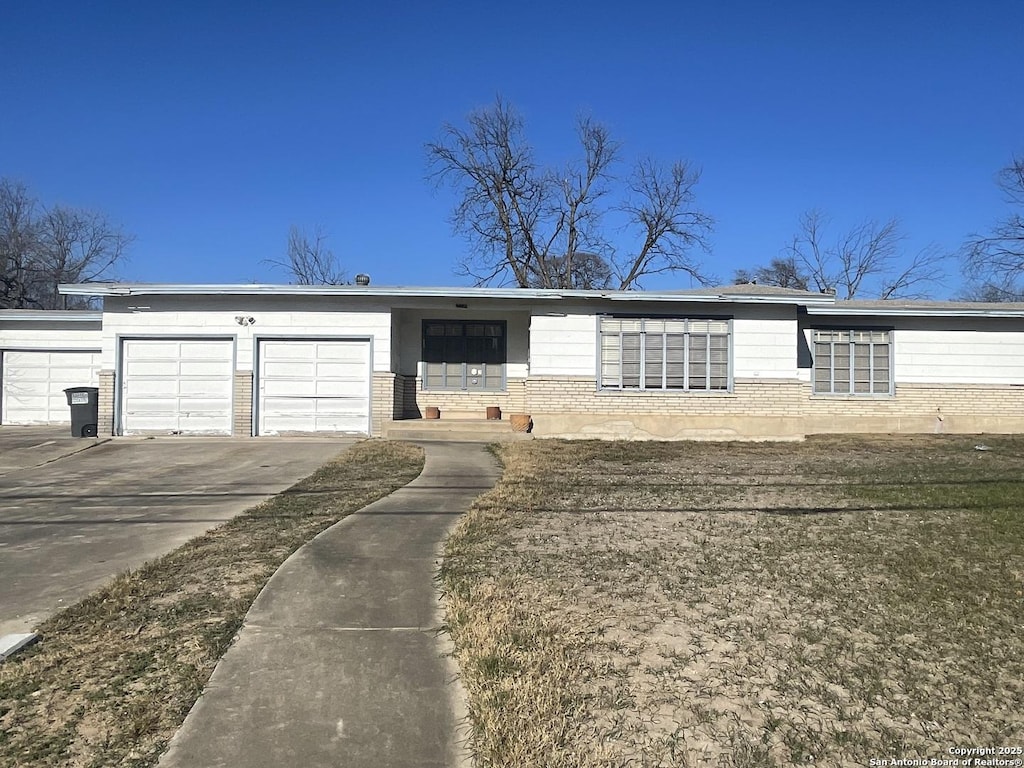 single story home featuring a garage and a front lawn