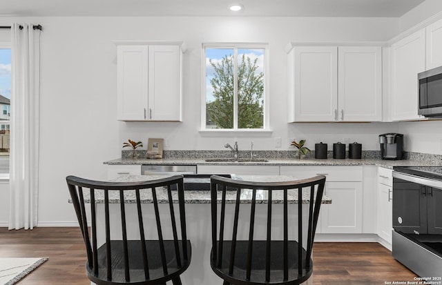 11707 Anselmo, San Antonio, TX 78254 - kitchen featuring appliances with stainless steel finishes, dark hardwood / wood-style floors, white cabinetry, sink, and light stone counters
