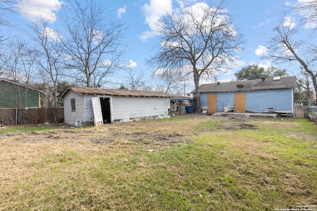 rear view of house featuring a yard and a storage unit