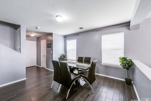 dining room featuring dark hardwood / wood-style flooring and a textured ceiling