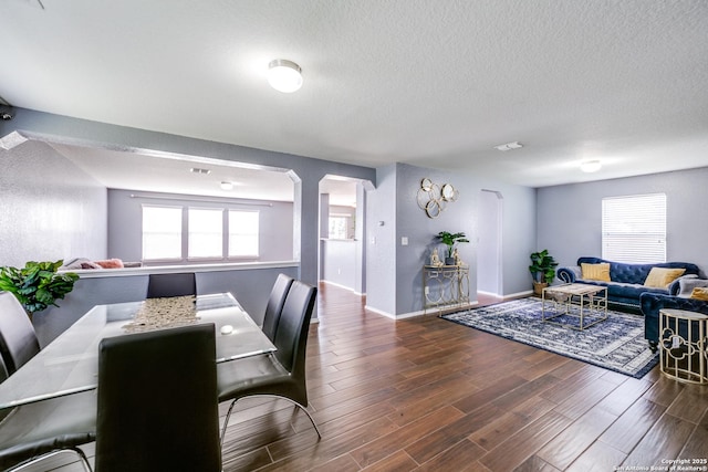 dining area featuring a wealth of natural light, dark hardwood / wood-style floors, and a textured ceiling