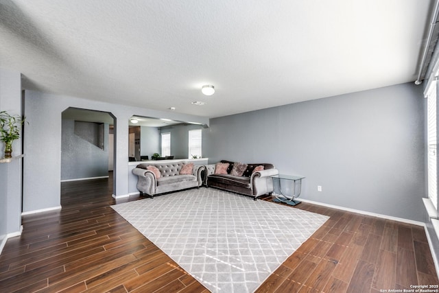 living room with dark hardwood / wood-style flooring and a textured ceiling