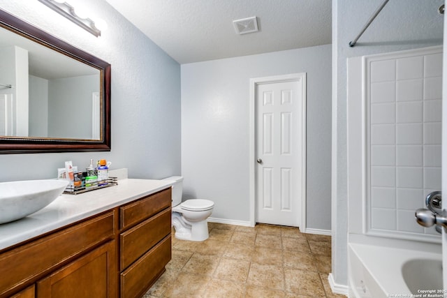 bathroom featuring vanity, tile patterned floors, a textured ceiling, and toilet