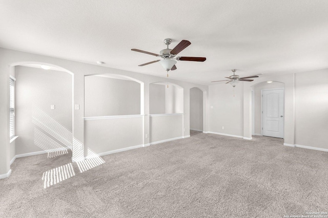 carpeted spare room featuring a textured ceiling and ceiling fan