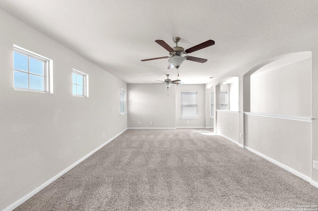 carpeted spare room with ceiling fan and a textured ceiling