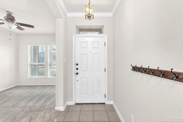 entryway with ornamental molding, light tile patterned flooring, and ceiling fan