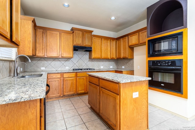 kitchen featuring sink, light tile patterned floors, black appliances, light stone countertops, and a kitchen island