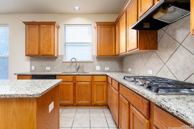 kitchen featuring extractor fan, stainless steel gas stovetop, sink, light tile patterned floors, and light stone counters