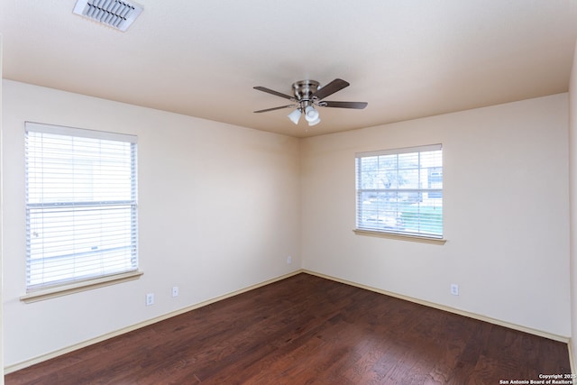 spare room featuring dark wood-type flooring and ceiling fan