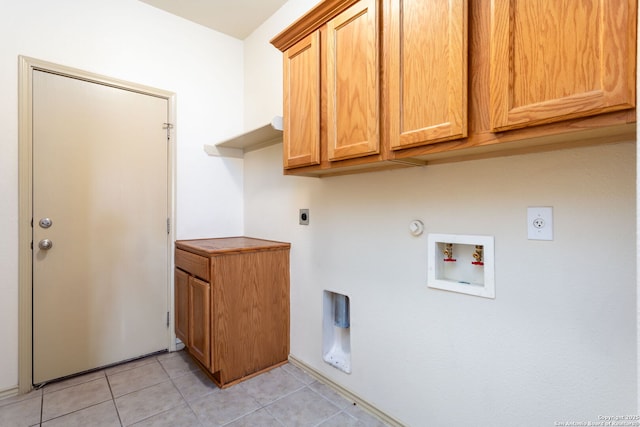 laundry area featuring light tile patterned flooring, gas dryer hookup, cabinets, washer hookup, and electric dryer hookup