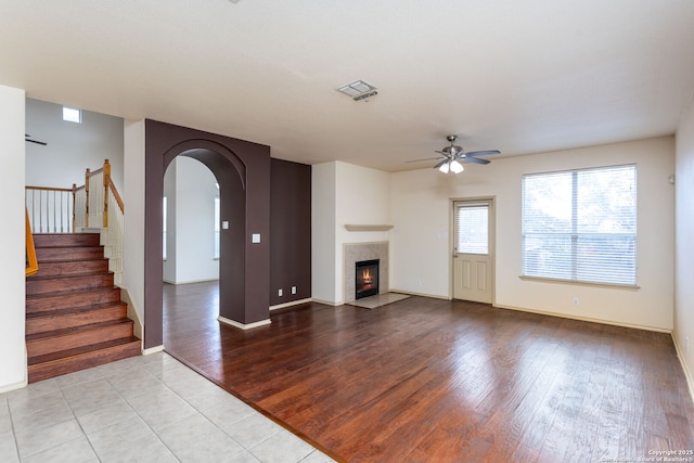 unfurnished living room featuring a fireplace, light hardwood / wood-style floors, and ceiling fan