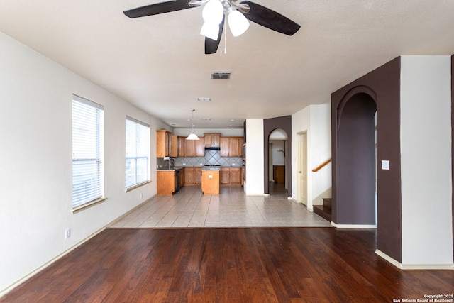 unfurnished living room with wood-type flooring and sink