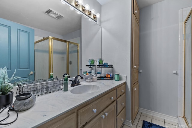 bathroom with an enclosed shower, vanity, and tile patterned flooring