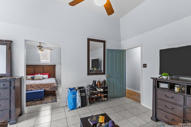 bedroom with vaulted ceiling, light tile patterned floors, and ceiling fan