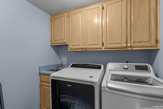 laundry area with sink, cabinets, and independent washer and dryer