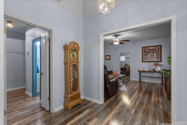 corridor with dark hardwood / wood-style floors and an inviting chandelier