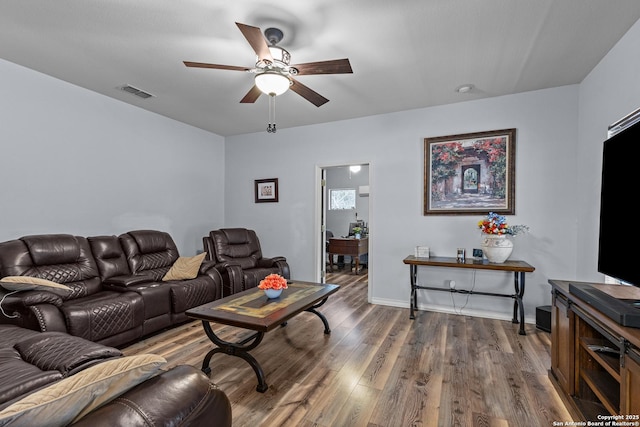 living room with dark wood-type flooring and ceiling fan