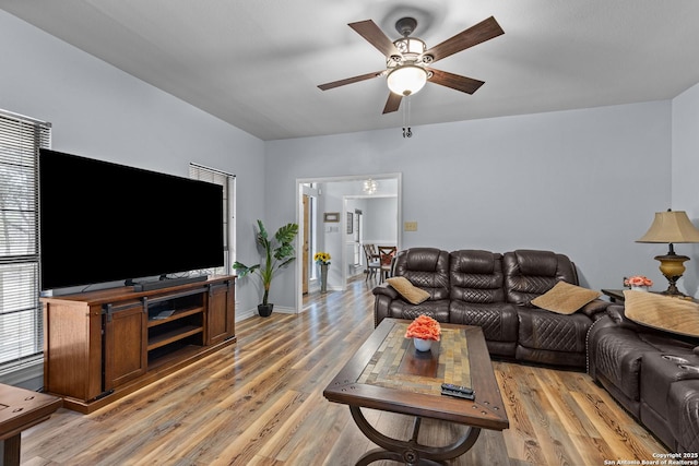 living room featuring light hardwood / wood-style flooring and ceiling fan