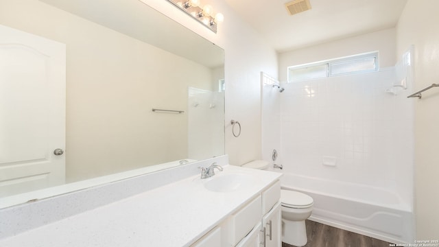 full bathroom with hardwood / wood-style flooring, vanity, bathtub / shower combination, and toilet