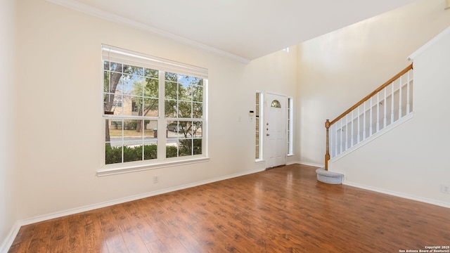 entryway with wood-type flooring and crown molding